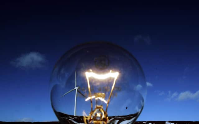 A wind turbine is pictured beside a light bulb at the Braes of Doune windfarm near Stirling, Scotland. The government has set a target for 10% of electricity to be generated from renewable sources by 2010.