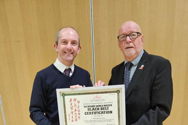 Sleaford Tae Kwon-Do instructor Daniel Pearce is congratulated on his promotion to 7th Degree World Master by Grand Master David Oliver, 9th degree, during a club event.