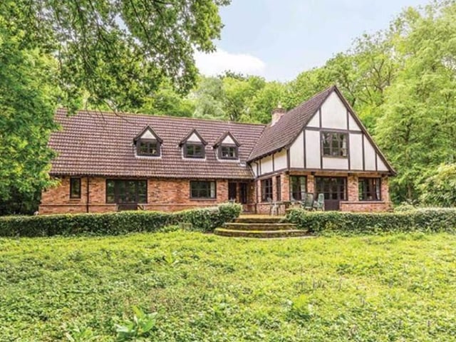 The front of the property with pillared steps leading to a wildflower garden.