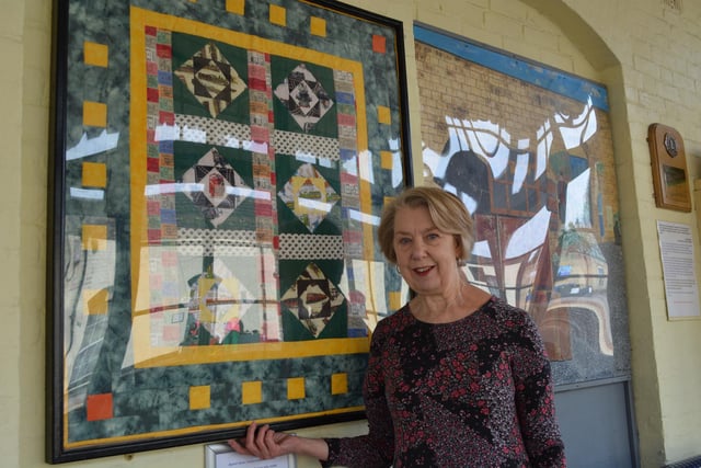 Pat Benson with the train-themed quilt she created, for which Brain Oxborrow made the frame