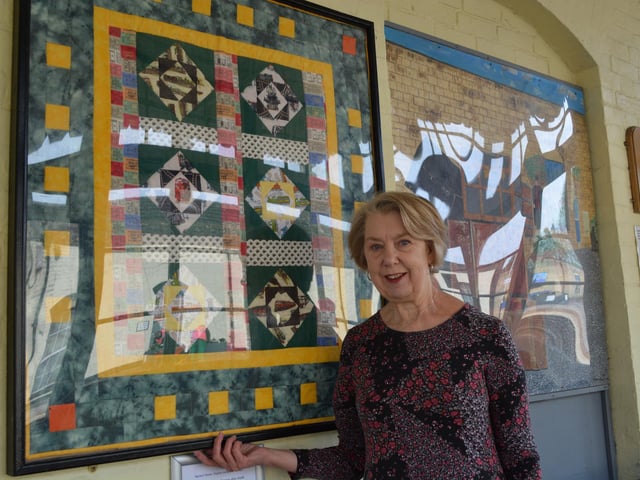 Pat Benson with the train-themed quilt she created, for which Brain Oxborrow made the frame