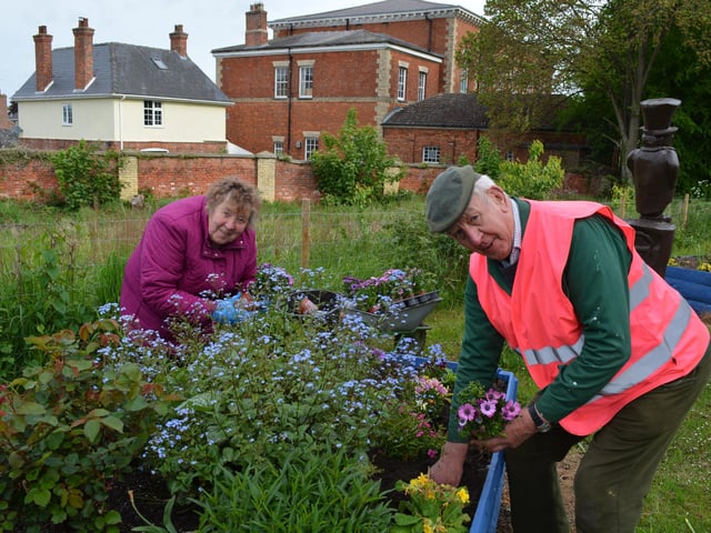 Ray and Mary Smart tending the beds on the station approach