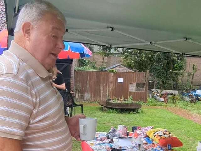 Ex Mayor of Skegness Pete Barry choosing what to buy from Alice themed Stall.