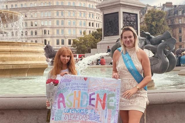 Hannah Lucy Brennan (right) holding the poster from Ashdene residents and staff when she visited Buckingham Palace last week.