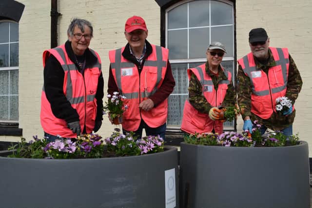 The dedicated volunteers set about setting the hundreds of plants it takes to make the station bloom