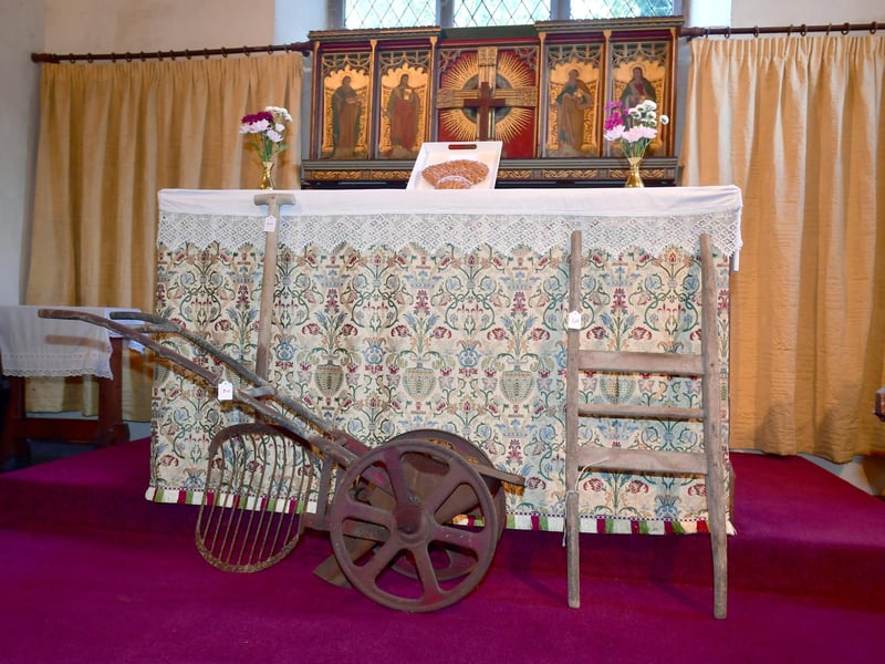 'We plough the fields and scatter...' artefacts in front of the altar in Hemingby Church.