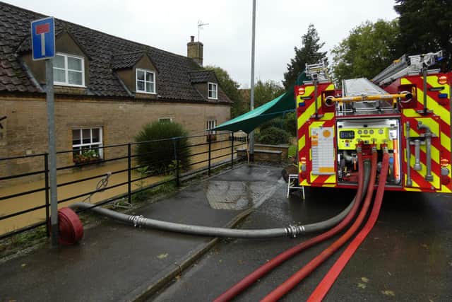 Firefighters pumping out flood waters from a cottage on Holdingham Lane/Lincoln Road, Sleaford. Photo: Robert Oates