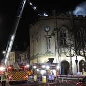 Firefighters on the aerial ladder platform continue to pour water onto the burning building. Photo: Andy Hubbert