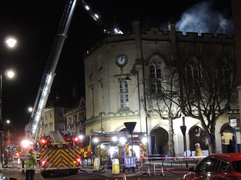 Firefighters on the aerial ladder platform continue to pour water onto the burning building. Photo: Andy Hubbert