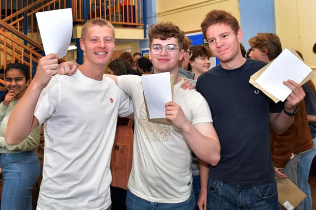 Cameron Ball, Archie Head, and Oscar Hoba collect their results at QEGS.