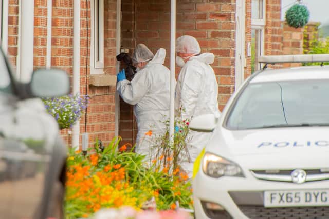 A crime scene investigator at the house in West Ashby where a 71-year-old woman was found with suspected stab wounds. Photo: John Aron Photography
