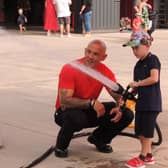 Jackson Wood, five, of Sleaford has a go with the hose with firefighter Stewart Hill.