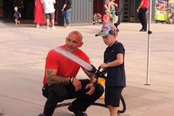 Jackson Wood, five, of Sleaford has a go with the hose with firefighter Stewart Hill.