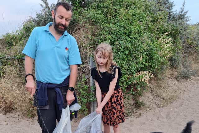 Sofia picking litter with her dad, Ray, and dog Bella.