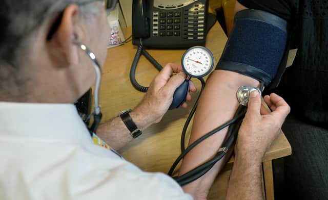 File photo dated 10/09/14 of a GP checking a patient's blood pressure. The majority of GPs are seeing patients over and above the "safe level" on a daily basis, a new survey suggests. Some 60% of family doctors say they see an average of 26-40 patients every day, according to a new survey by GP publication Pulse. Issue date: Monday August 21, 2023.