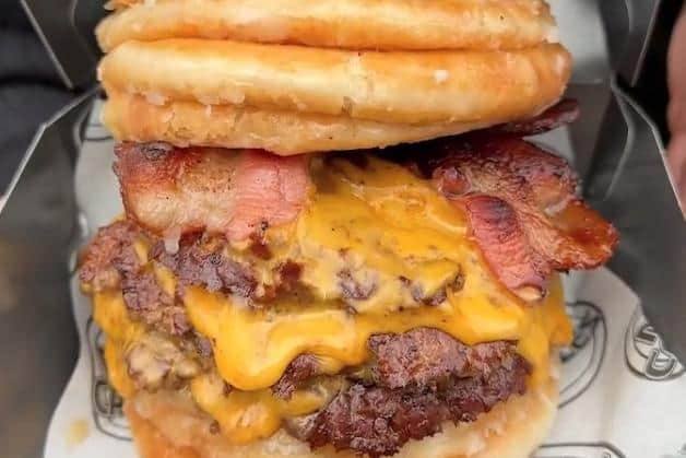 he gut-busting meal contains three beef patties, six slices of cheese and two rashers of bacon - all smothered in melted butter or Biscoff spread. It is wrapped in eight sugar-covered doughnuts and contains 3,180 calories - the same as six Big Macs or over three roast dinners.