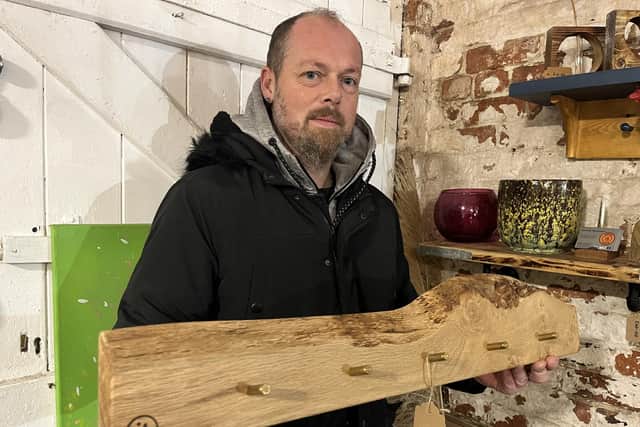Mark with a coat rack made from wood and spent bullets.