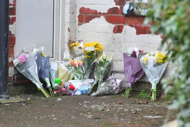 Flowers left by the door of the basement  flat where the  tragedy was discovered.