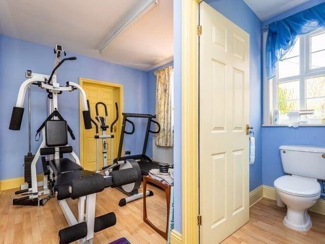 The gym, with WC off, and door leading to the triple garage.