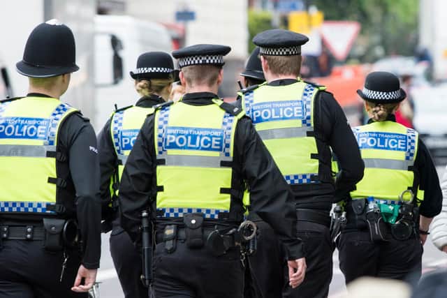 Six British Transport Police officers patrol the street in Highbury, London.