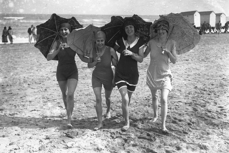 Four bathing belles shading themselves with parasols on the beach at Skegness in 1926.