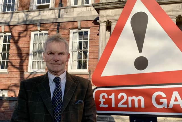 Council Leader Coun Martin Hill with the £12m funding campaign sign. Photo: Daniel Jaines