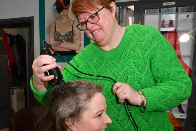 Anna Williams cutting Samantha Kettle's hair off for charity.