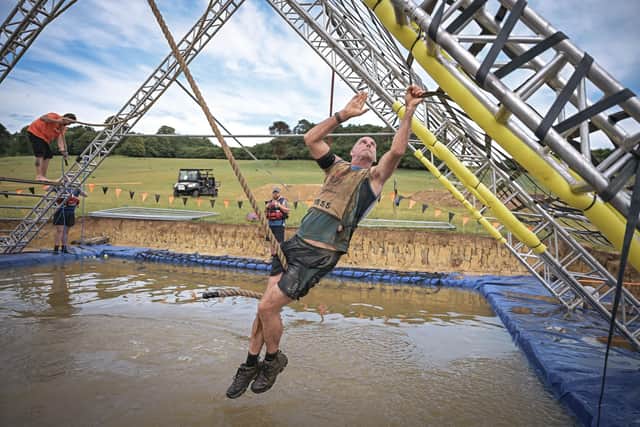 Ben swinging across the 'Shaft It' open water obstacle at the World's Toughest Mudder event at Belvoir Castle.