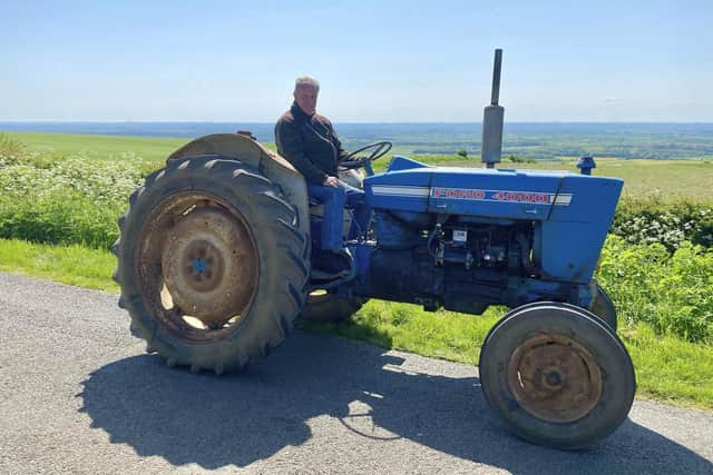 Ian Dawson on his Grandad's vintage tractor, looking out from Nettleton Top where his family once farmed. This is part of the Nettleton Tractor Run route. Image: Hannah Dawson