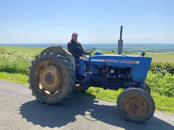 Ian Dawson on his Grandad's vintage tractor, looking out from Nettleton Top where his family once farmed. This is part of the Nettleton Tractor Run route. Image: Hannah Dawson