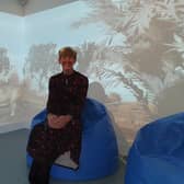 Winchelsea School headteacher Helen Duckett sat in the Smartpod on a rumble bean bag and the immersive screens behind.