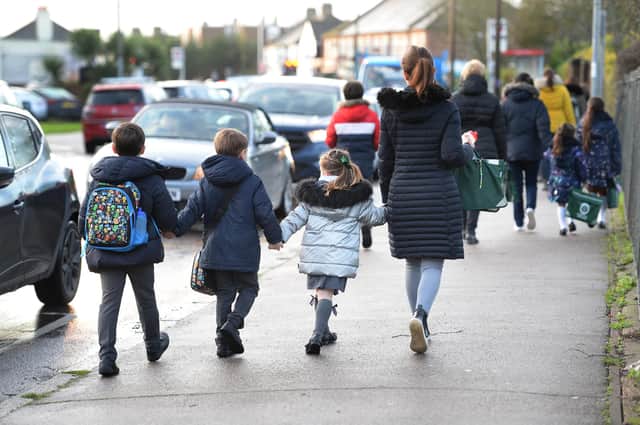 Parents walk their children to school in Hornchurch, Essex, past stationary vehicles near to the school grounds. PA Photo. Picture date: Friday January 17, 2020. Photo credit should read: Nick Ansell/PA Wire