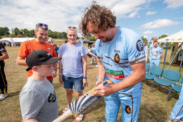 Yorkshire and England cricketer Ryan Sidebottom signing a bat for a young fan.