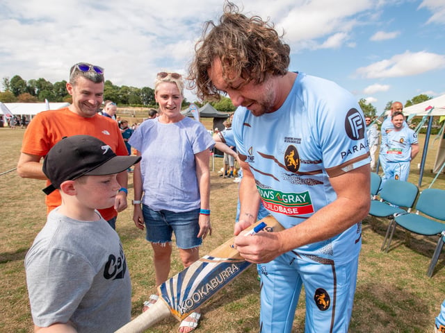 Yorkshire and England cricketer Ryan Sidebottom signing a bat for a young fan.
