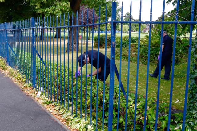 Police search through a hedgerow in Central Park, in Boston.