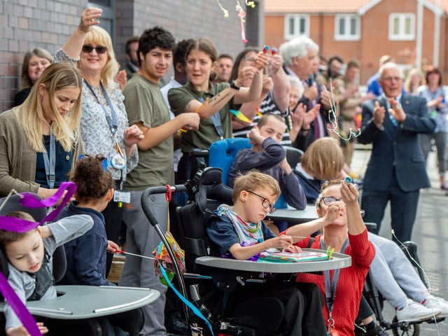 Parents, pupils and staff let off party poppers to celebrate the opening of their new school.