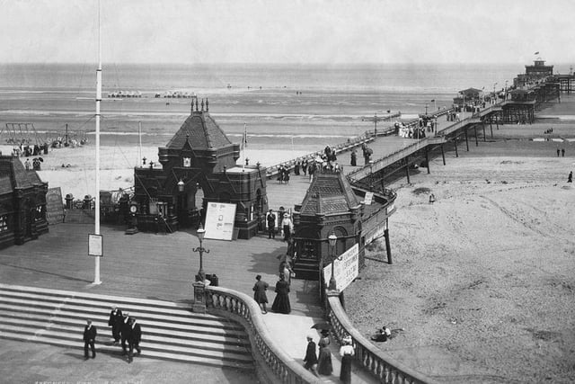 Locals and tourists take in the fresh air on the The Pier at Skegness, circa 1900.
