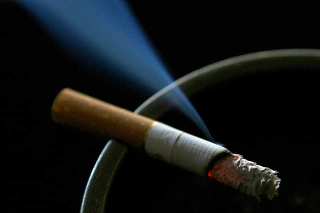 A cigarette burning on an ash tray.