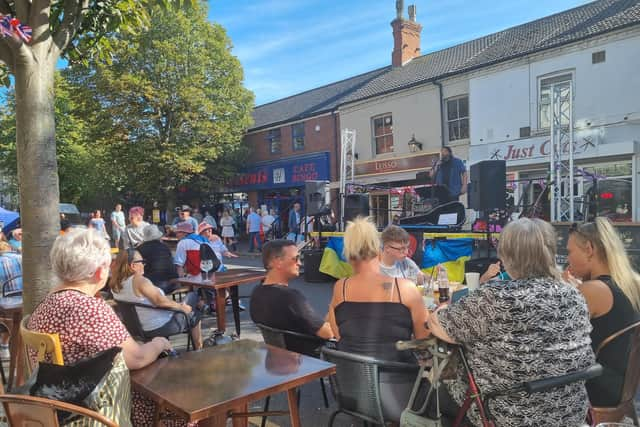 Shoppers take a break at the Artisan coffee shop to enjoy the live music.