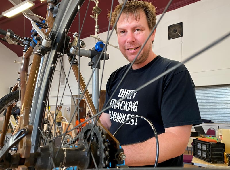 Ian Round repairs a broken bicycle.
Photo by Chris Frear