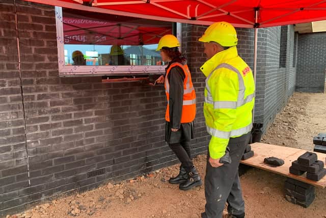 Victoria Atkins MP laying a brick at the topping out ceremony.