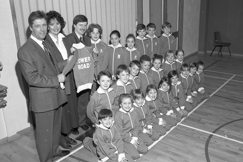 Tony and Pat Lennon presenting Tower Road School headmaster David Lloyd with 40 tracksuits, 20 bought by Labelking and the other 20 by the PTA. Pictured wearing the tracksuits are some of the Tower Road pupils.