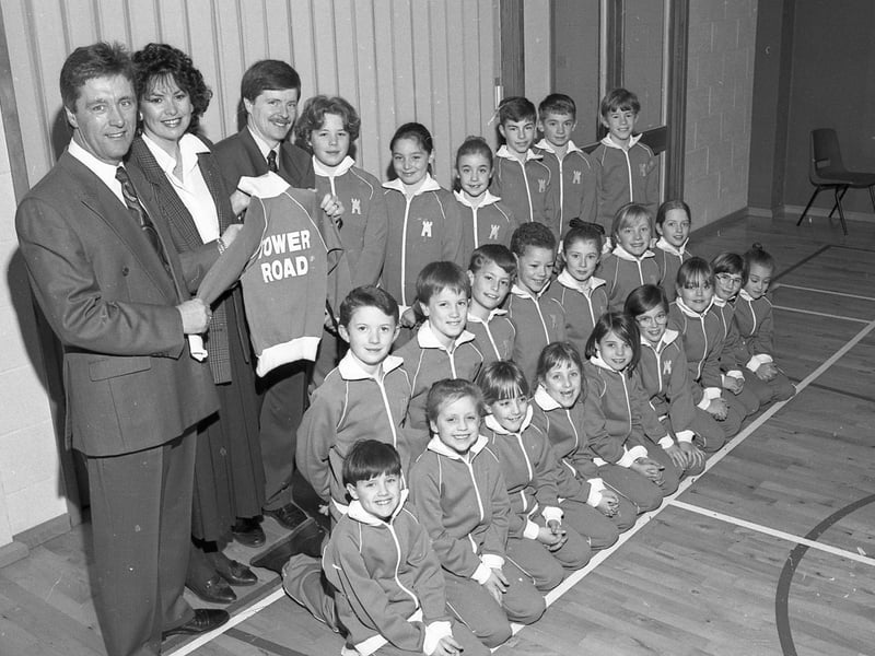 Tony and Pat Lennon presenting Tower Road School headmaster David Lloyd with 40 tracksuits, 20 bought by Labelking and the other 20 by the PTA. Pictured wearing the tracksuits are some of the Tower Road pupils.