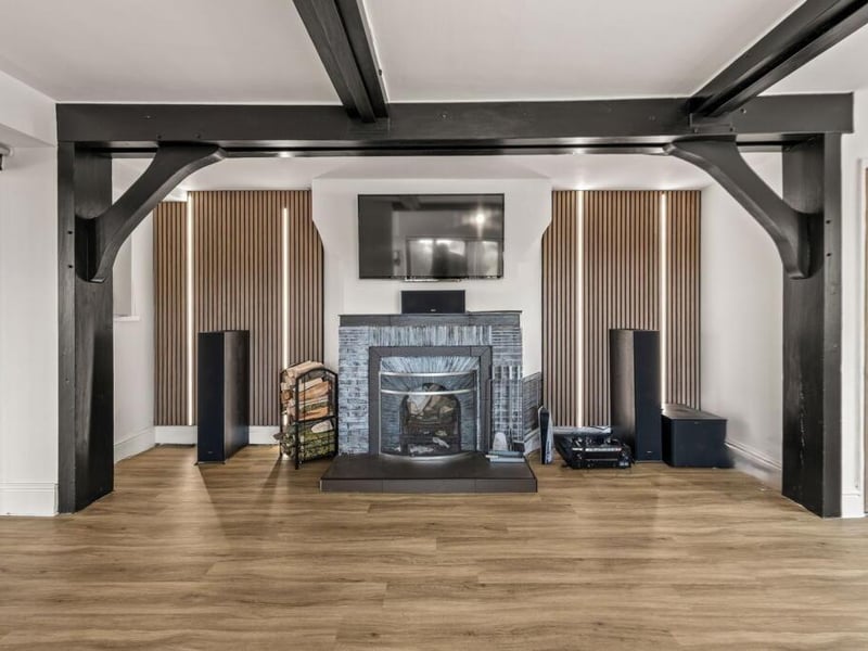 The media room's feature beams and fireplace.
