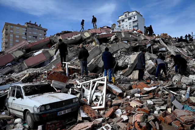 Residents and rescue personnel search for victims and survivors through the rubble of buildings in Kahramanmaras, the day after a 7.8-magnitude earthquake struck the country's southeast, on February 7, 2023. (Photo by OZAN KOSE/AFP via Getty Images)