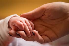 File photo dated 23/01/16 of a mother holds the hand of a new baby. Bereaved parents are being reminded by the Government to check whether they could be eligible for backdated payments. Issue date: Saturday August 5, 2023.