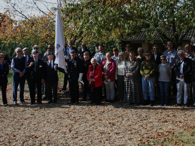 The whole Ruskington veterans group at the memorial gardens with their new standard.
