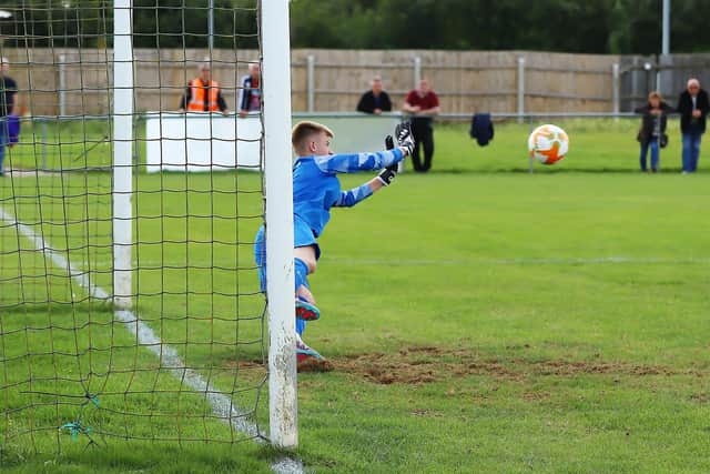 Liam Flitton dives to make a crucial save in the shoot-out. Photo: Steve W Davies Photography.