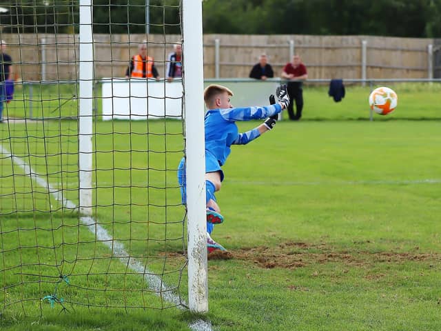 Liam Flitton dives to make a crucial save in the shoot-out. Photo: Steve W Davies Photography.