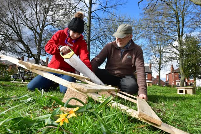 Lauren Williams cutting wood for the Bug Hotel, helped by wood craftsman Peter Tree.